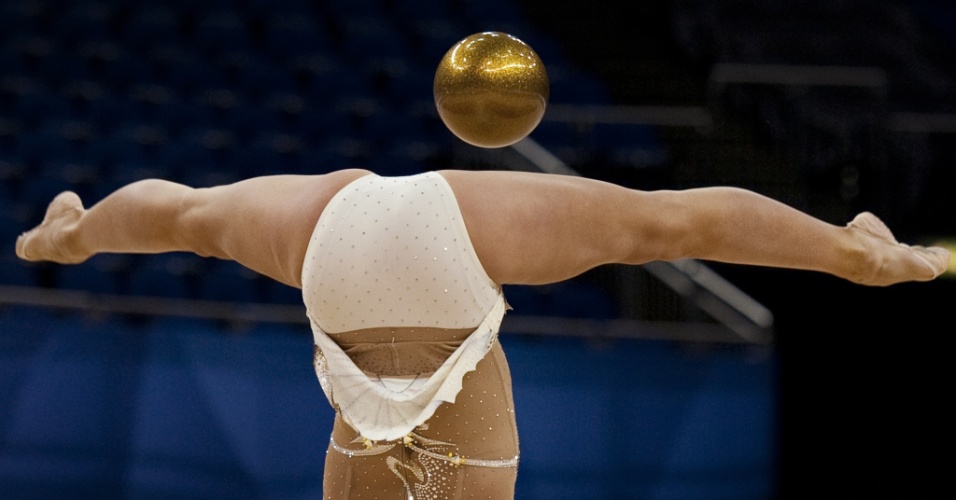 Russa Daria Kondakova sustenta uma bola nas pernas durante sua apresentação nas finais; ela ficou com a medalha de ouro no individual geral do Pré-Olímpico